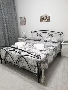 a bedroom with a bed with a black frame at Casa del Sole - Avola in Avola