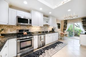 uma cozinha com armários brancos e electrodomésticos de aço inoxidável em Nido en la Ventana em Tucson