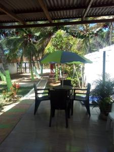 a patio with a table and chairs and an umbrella at Villa mar in Puerto Colombia