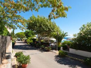 a street with trees and plants on a sunny day at Les Hauts de Pinarello in Sainte-Lucie de Porto-Vecchio