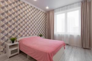 a bedroom with a pink bed and a window at 3к семейные апартаменты с видом на акваторию in Kazan