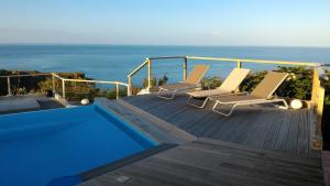 a deck with two lounge chairs and a swimming pool at Infiniti Blue in Bouillante