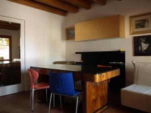 Casa delle Bruscole في كونيليانو: مطبخ مع طاولة وكراسي خشبية