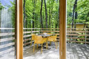 a screened in porch with a table and chairs at Treehouse Lika1 in Gospić