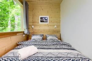 two beds in a room with a window at Treehouse Lika1 in Gospić