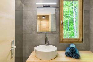 un bagno con lavandino e specchio di Treehouse Lika1 a Gospić