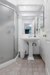 a white bathroom with a sink and a shower at Large 1 Bedroom Apartment, Home Theater, Fireplace in Berkeley