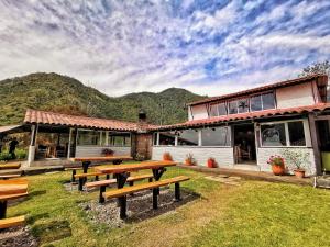 a group of picnic tables in front of a building at Palmas de Cocora in Salento