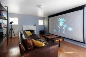 a living room with a couch and a large screen at Large 1 Bedroom Apartment, Home Theater, Fireplace in Berkeley