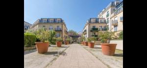 a row of pots of plants in front of buildings at Disney, sunny comfortable 2 bedrooms family apartment, 8 pers, wifi, NETFLIX in Chessy