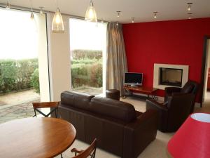 a living room with a couch and a table at Gites "Pieds dans L'Eau" ou "Plage" en FRONT DE MER à Asnelles , 3km d'Arromanches, 10km de Bayeux in Asnelles