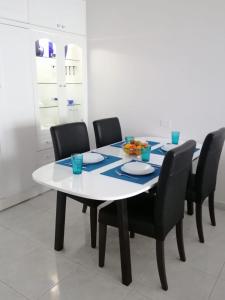 mesa de comedor con sillas negras y mesa blanca en Doñana12 by SunHousesCanarias, en Patalavaca