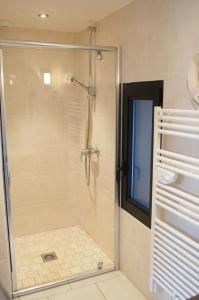 a shower with a glass door in a bathroom at Gîtes "Plage" ou "Pieds dans l'Eau" en FRONT DE MER à Asnelles , 3km d'Arromanches, 10km de Bayeux in Asnelles