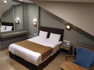 イスタンブールにあるジャカランダ ホテルのベッドルーム(大型ベッド1台、青い椅子付)