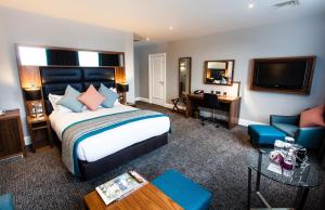 a hotel room with a large bed and a desk at Crowne Plaza Leeds by IHG in Leeds
