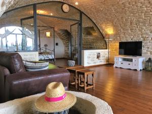 ein Wohnzimmer mit Sofa und Hut in der Unterkunft Petit Paradis Bellevue in Montpezat