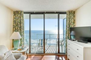 a living room with a television and a balcony with the ocean at Cloud 9 on the Ocean in Myrtle Beach