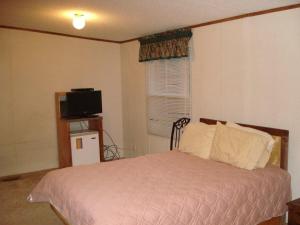 a bedroom with a bed and a television in it at Comfort Green Motel in Thayer