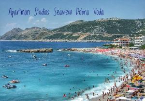 a beach with a bunch of people in the water at Studios Seaview in Dobra Voda