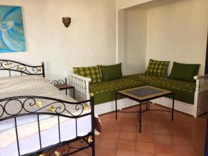 a room with a couch and a bed and a table at Villa Jardins de la Lagune in Oualidia +43 photos