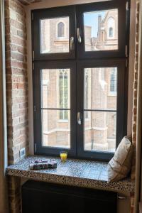 a window with a view of a brick building at 2/3 APARTMENTS Old Town in Wrocław