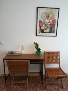 ヴェローナにあるBlunotteの机と椅子2脚(テーブルと絵画の横)