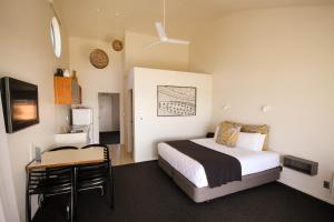 a bedroom with a bed and a table with a desk at Tasman Holiday Parks - Papamoa Beach in Papamoa