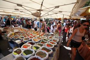 una folla di persone che si aggirano intorno a un mercato con molte ciotole di cibo di La Javanaise a Saint-Aygulf