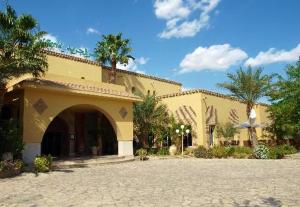 ein Gebäude mit einem Innenhof mit Bäumen und einer Terrasse in der Unterkunft Ksar El Jerid Tozeur in Tozeur