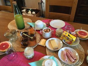 un tavolo con piatti di cibo e una bottiglia di succo verde di La Lézardière a Épeigné-les-Bois Altre 24 foto