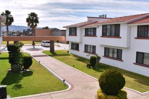 un edificio de apartamentos con patio y aparcamiento en La Posada Hotel y Suites, en San Luis Potosí