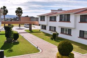 un immeuble d'appartements avec une cour et un parking dans l'établissement La Posada Hotel y Suites, à San Luis Potosí