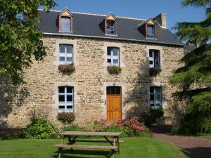 a brick house with a wooden door and a picnic table at Domaine Arvor & Spa in Lanvallay