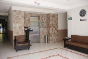 una sala de espera con 2 sillas y un ascensor en Hotel Niza Zona Piel, en León