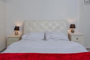 um quarto com uma cama branca com duas mesas de cabeceira em Windsor House em Derry