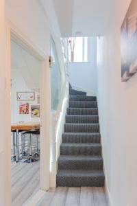 eine Treppe in einem Haus mit einer weißen Wand in der Unterkunft Windsor House in Derry Londonderry