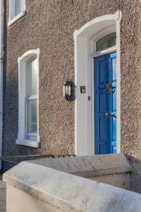 eine blaue Tür in einem Gebäude mit Fenster in der Unterkunft Windsor House in Derry Londonderry