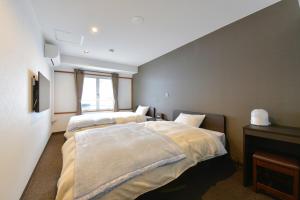 a bedroom with two beds and a window at G-SQUARE in Yamagata