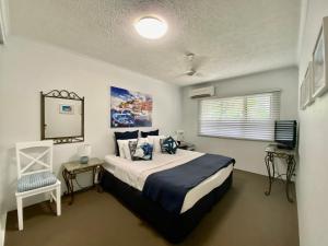 een slaapkamer met een bed en een televisie. bij Cairns Beach Resort in Cairns