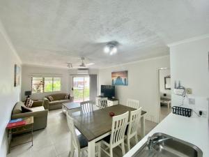 a kitchen and living room with a table and a couch at Cairns Beach Resort in Cairns
