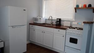 a kitchen with white cabinets and white appliances at The Sequoia Hut! in Three Rivers