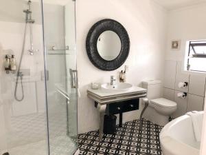a bathroom with a sink and a toilet and a mirror at Orewa Beachcomber in Orewa