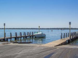 a row of boats are docked at a pier at Twin Waters Caravan Park in Dawesville