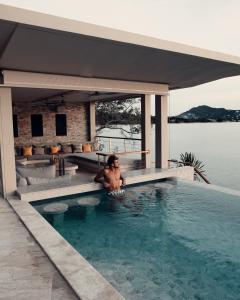 a man in a swimming pool at a resort at Moonstone - Samui's Premier Private Villa in Bang Rak Beach