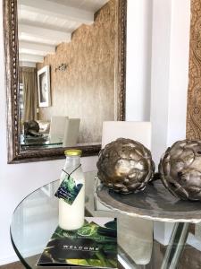 a glass table with a bottle of milk and a mirror at Orewa Beachcomber in Orewa
