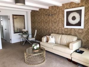a living room with a couch and a table at Orewa Beachcomber in Orewa