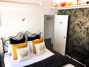 a bedroom with a bed with yellow and white pillows at Orewa Beachcomber in Orewa
