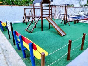 a playground with a slide and a swing at Ed.fragatas residence in Bertioga