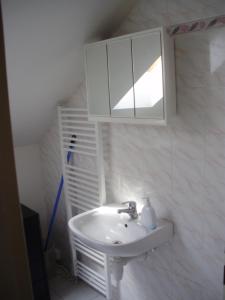 a white bathroom with a sink and a mirror at Apartmány u Jitky in Zlín