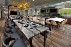 a dining room with a large marble table and chairs at Holiday Inn & Suites Arden - Asheville Airport, an IHG Hotel in Arden